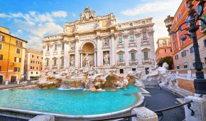 Trevi Fountain in Rome, Italy. Ancient fountain. Roman statues at piazza in old medieval city among traditional italian houses and street lamps. Famous landmark. Touristic destination for vacation.