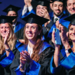 Studentesse e studenti con la toga che applaudono