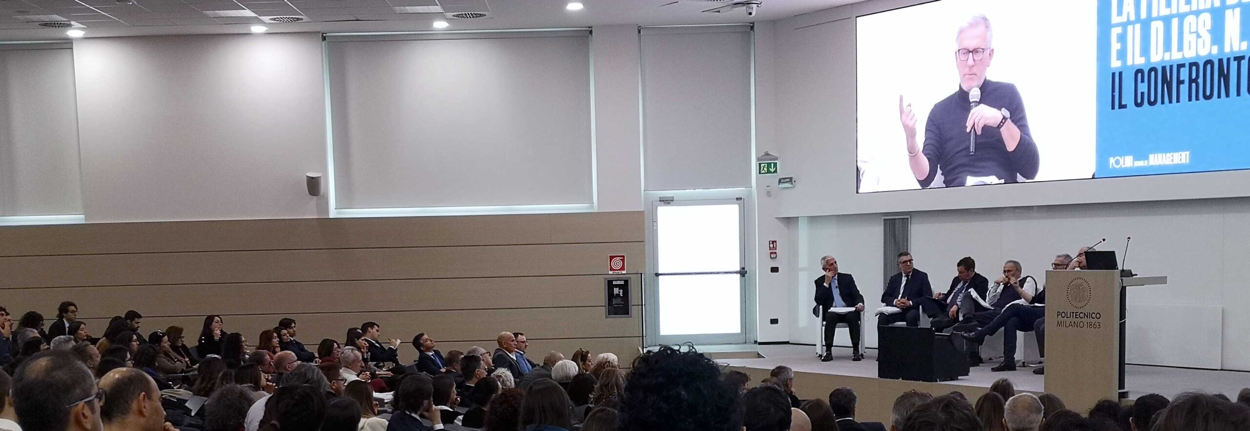 Aula con platea e relatori durante evento